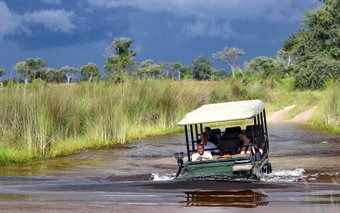 Photo of luxury safari vehicle crossing deep river