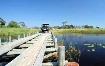 Photo of a luxury safari vehicle crossing a wooden bridge