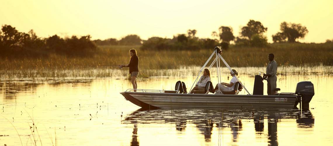 Photo of tourists in a boat catching tiger fish in the Okavango Delta